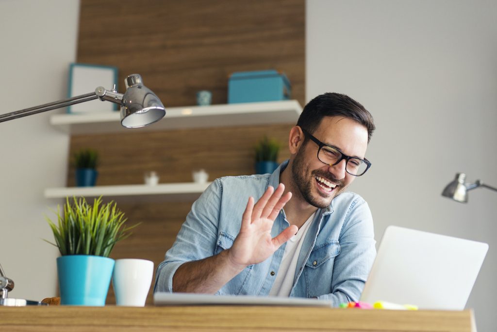 Smiling man having video call and waving