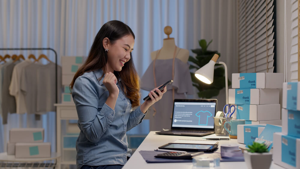 Small business owner with boxes around her desk
