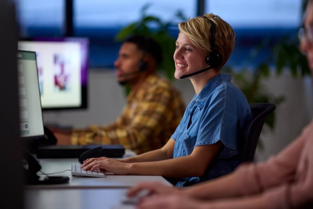 Two people sitting at a desk answering calls as part of call forwarding service