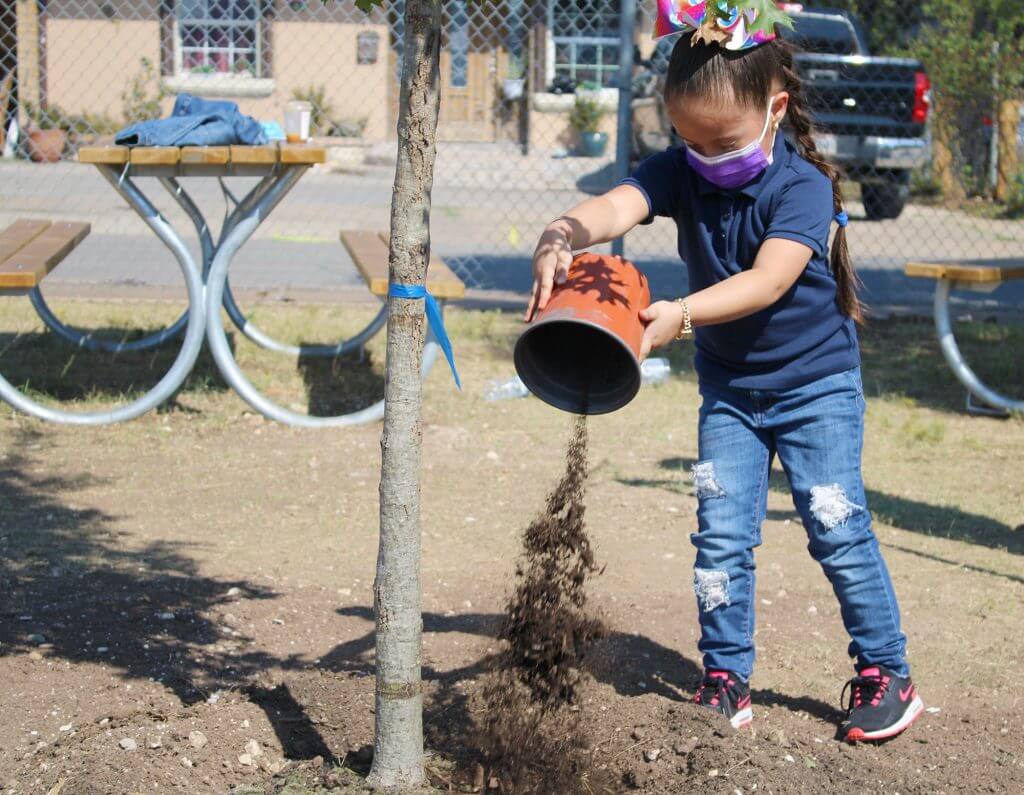 girl throwing soil on tree