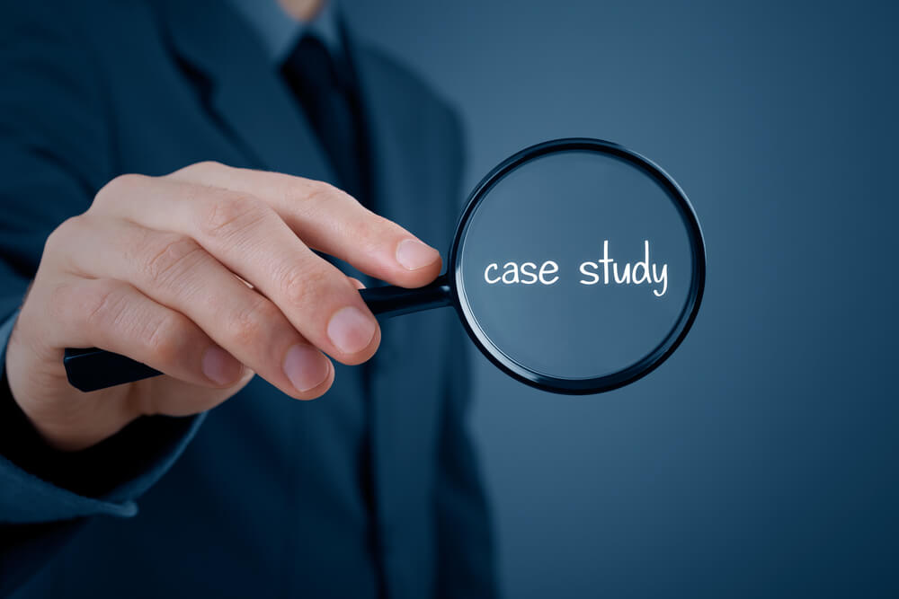 Businessman holding magnifying glass with “Case study” magnified