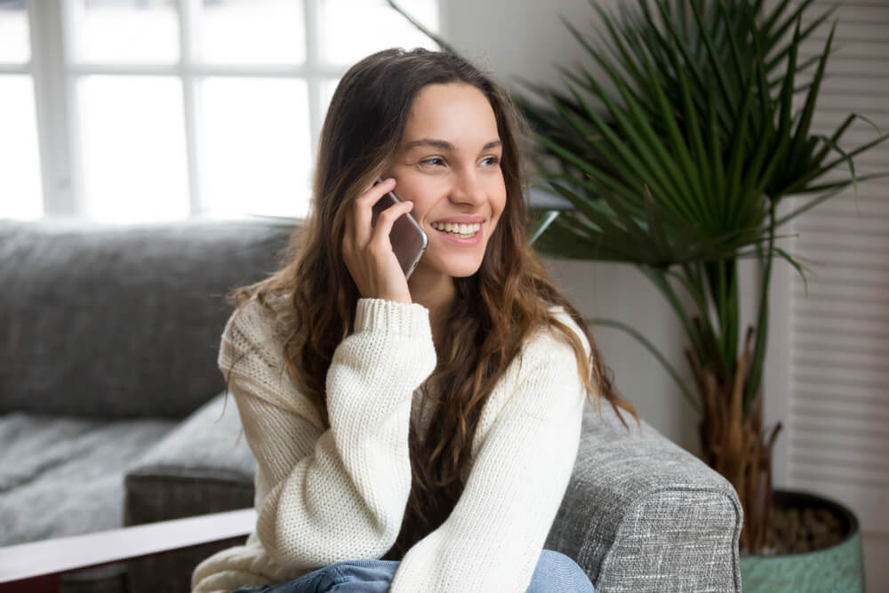 Smiling woman in customer interaction on a smartphone call