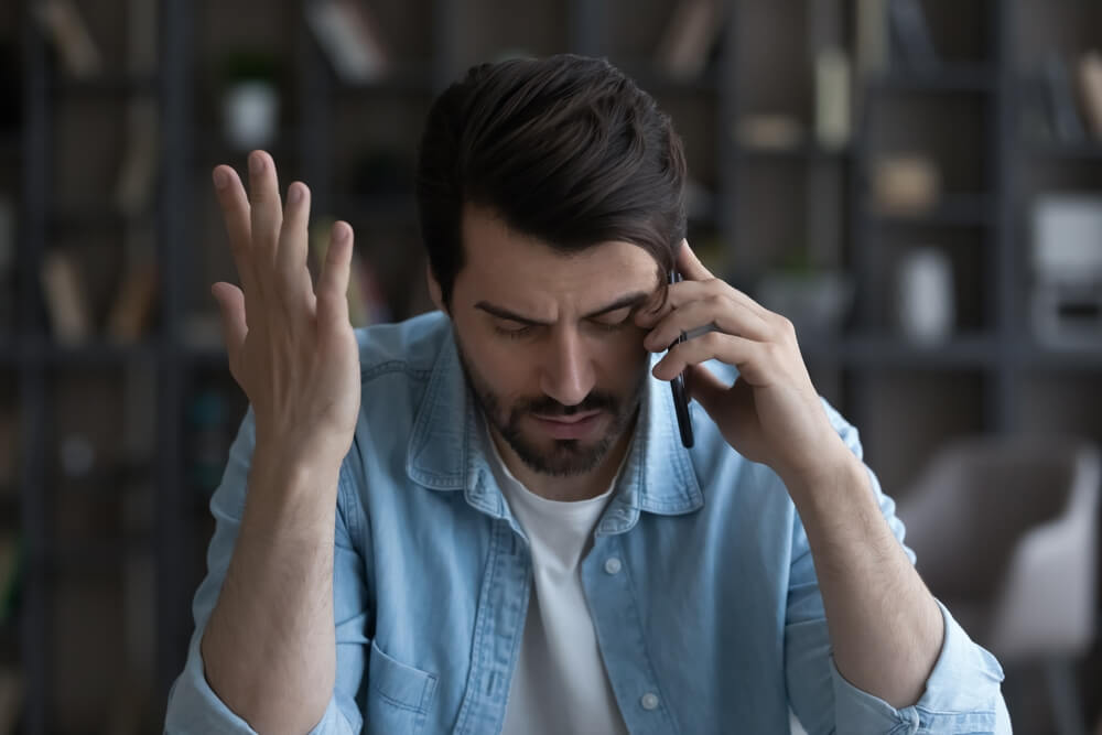 Frustrated man talking in phone 

