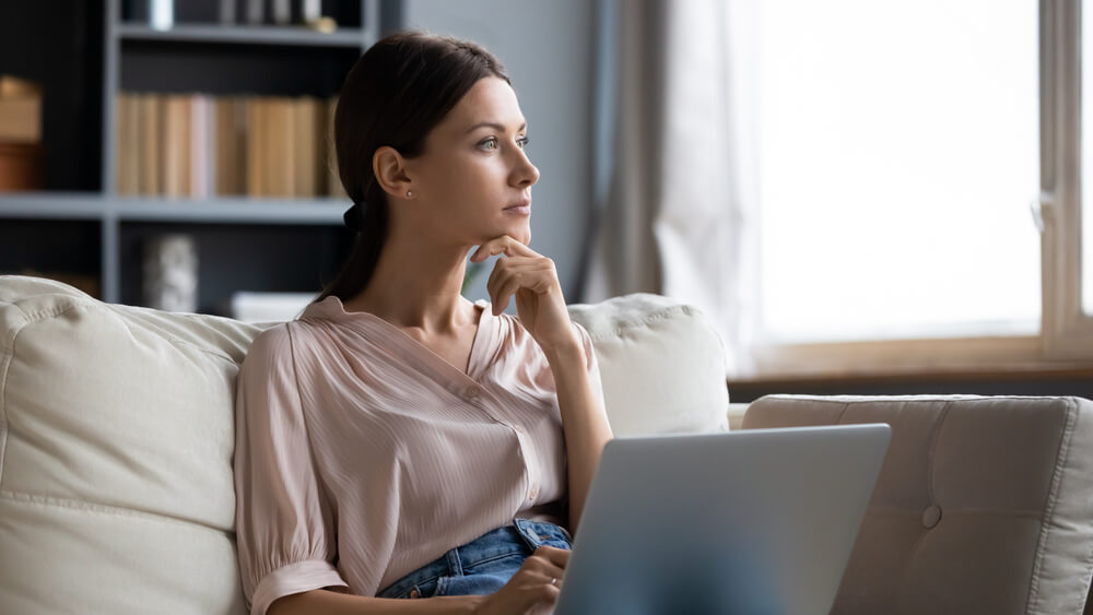 Women sitting with laptop and thinking 