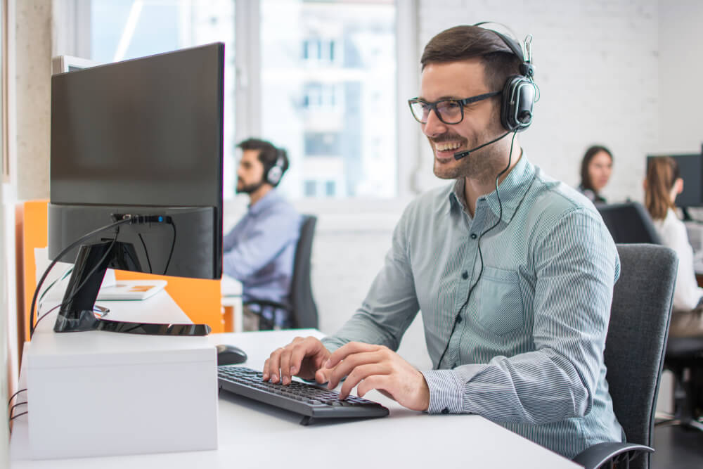 man taking in phone to resolve customer queries. 

