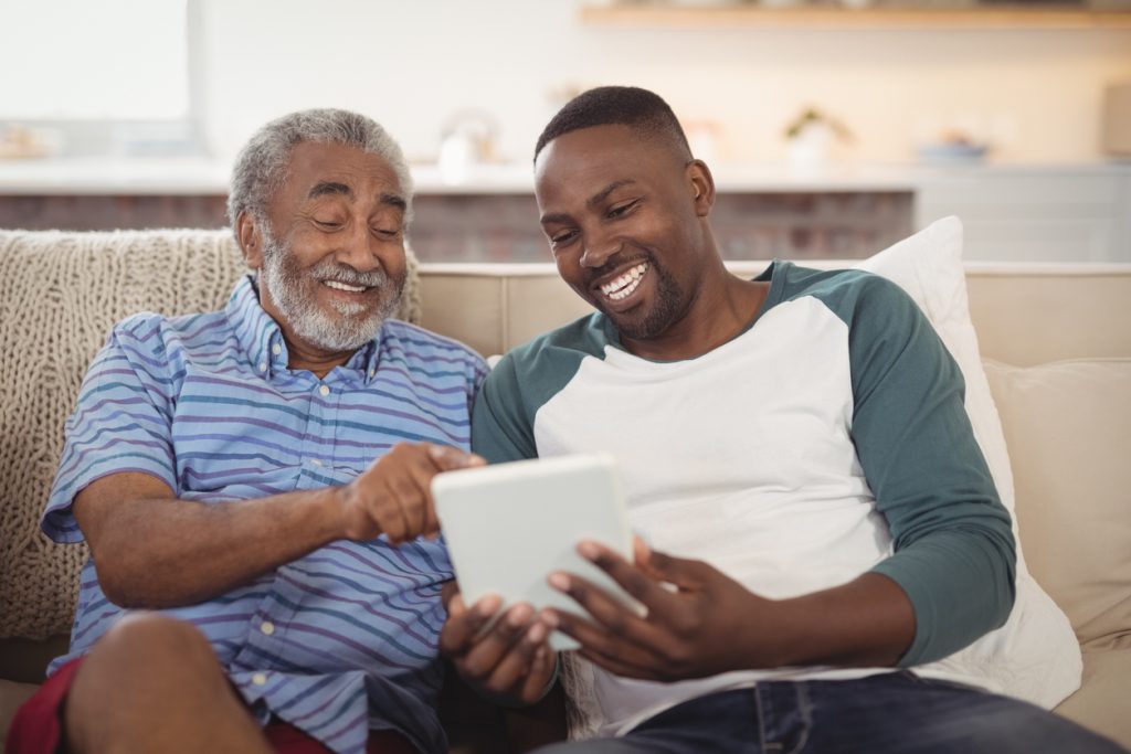 father and son smiling at a tablet