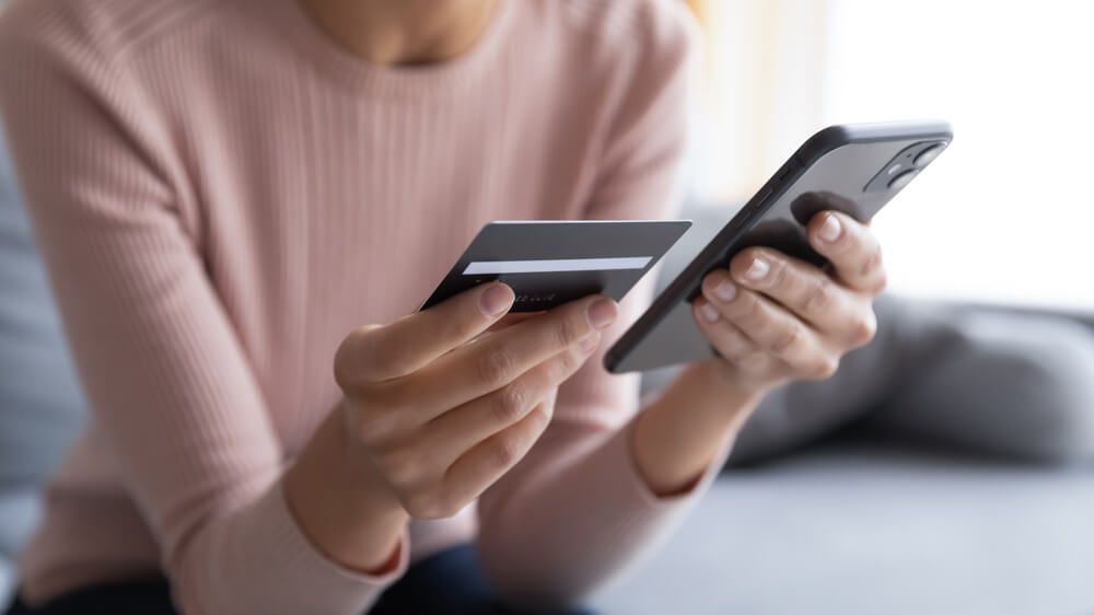 women holding a phone and a credit card 