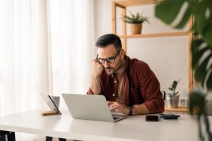 man watching something in his laptop