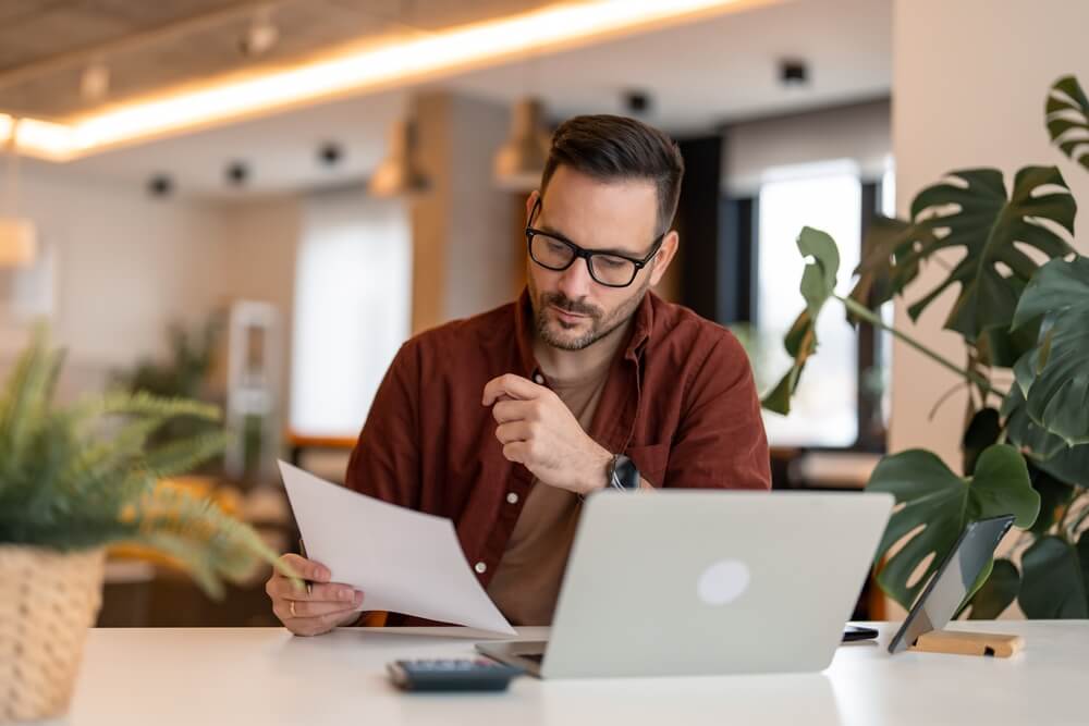 man holding a paper and looking at it 