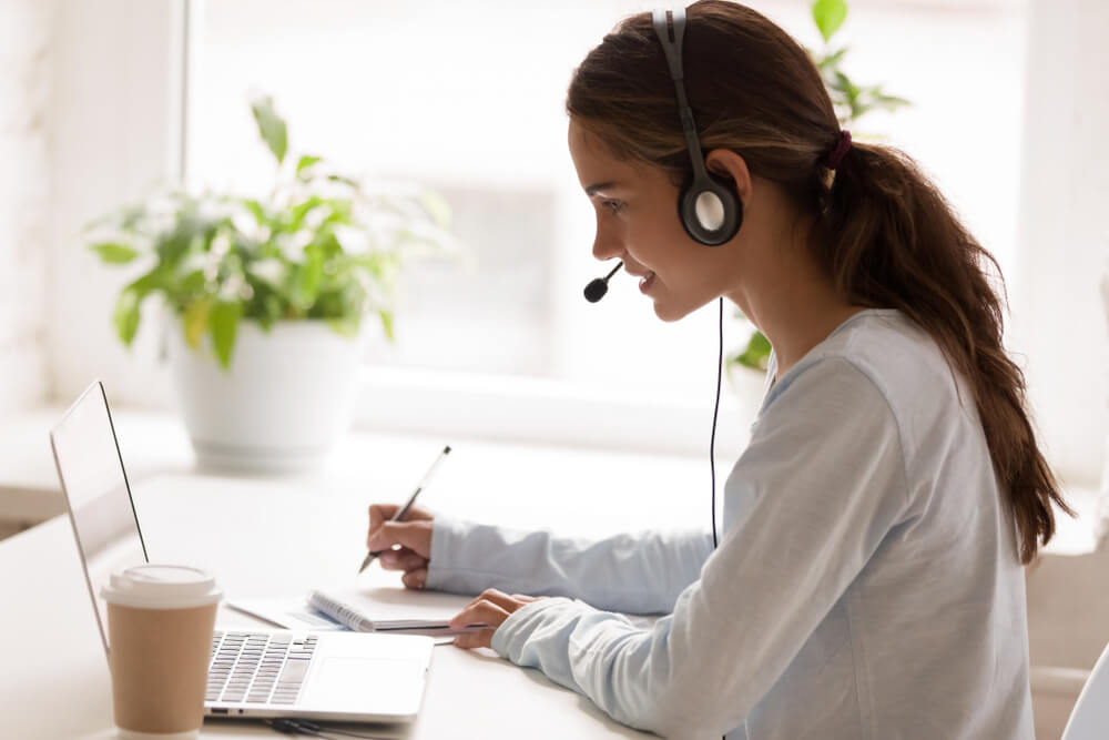 women wearing a headset and writing 