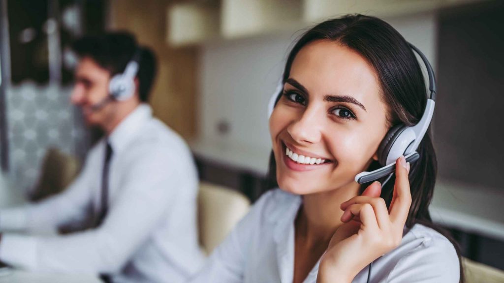 Smiling woman answering customer calls using a headset