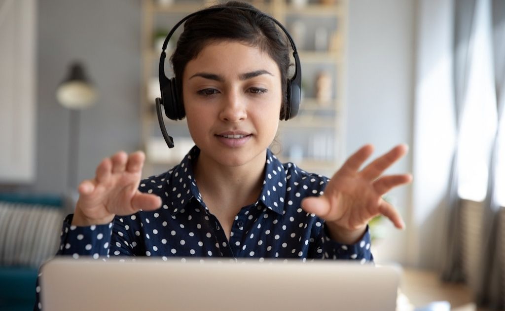 Woman answering a call on a headset, working at a telephone answering service.