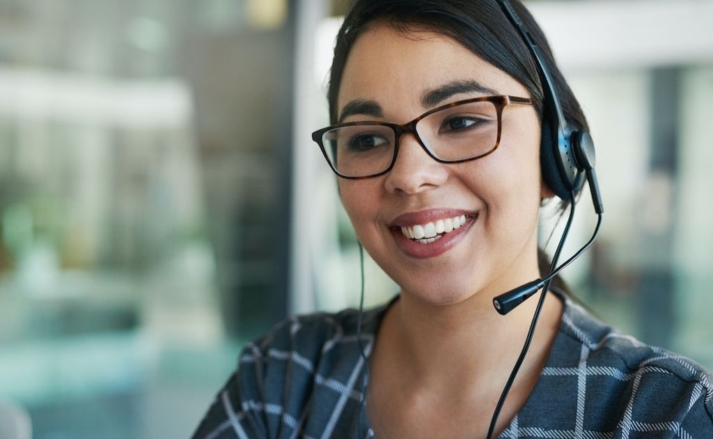 Woman on a headset, answering calls as part of a telephone answering service.