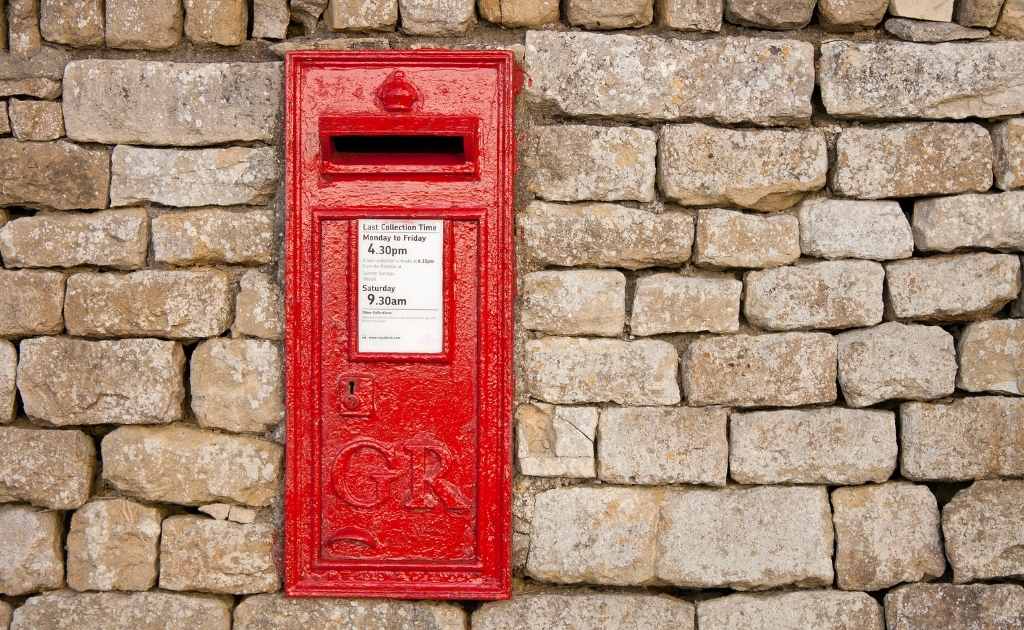 Beige brick wall, with a red UK post box. Having a UK address helps to create a business presence.