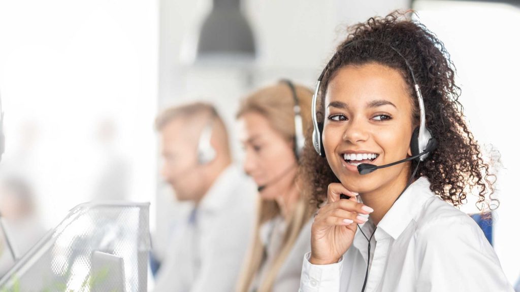 Smiling UK virtual receptionist wearing a headset answering calls