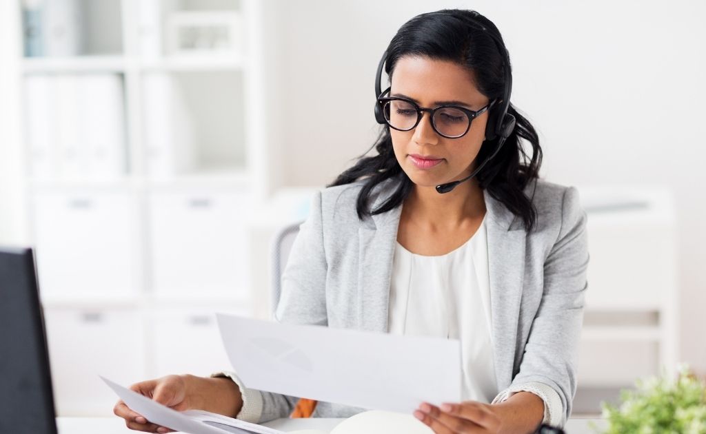 Female UK-based virtual receptionist looking at paper on call