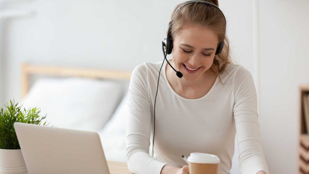 Smiling woman, answering customer calls as a virtual receptionist