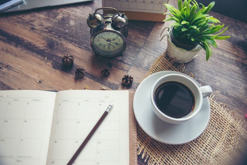 Paper diary and coffee on table