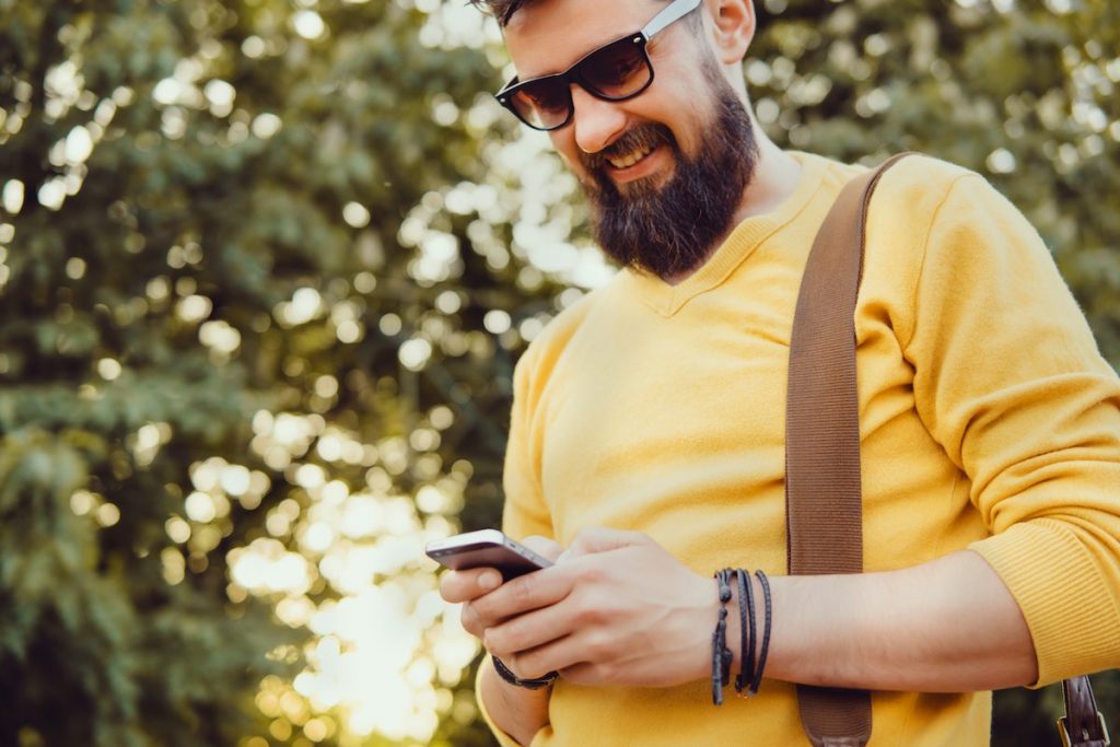 Smiling man checking his online appointment time on smartphone