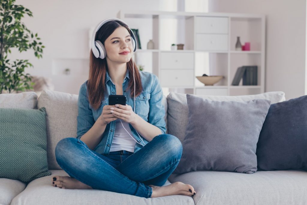 Smiling woman listening to podcast as part of learning time