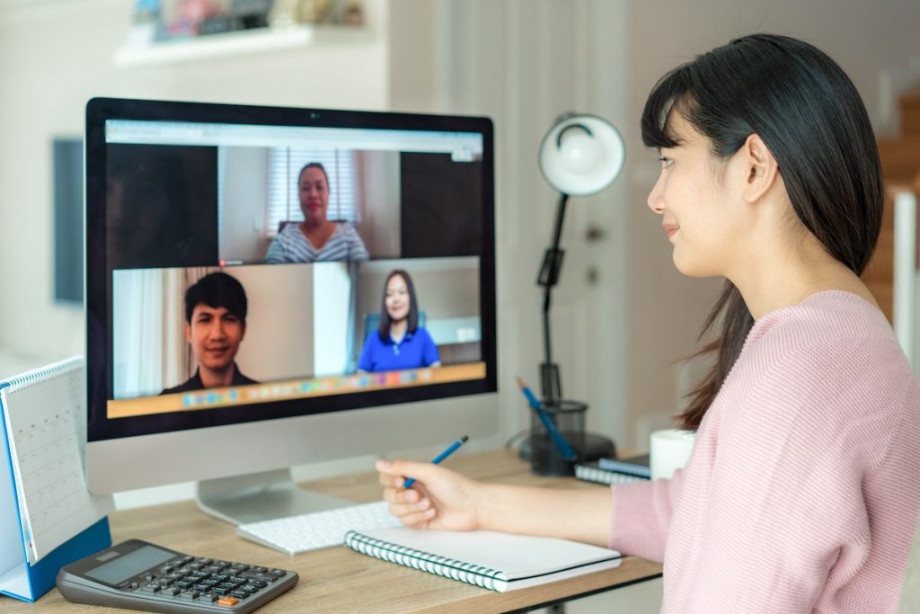 Business woman talking to her colleagues from home on hybrid work model