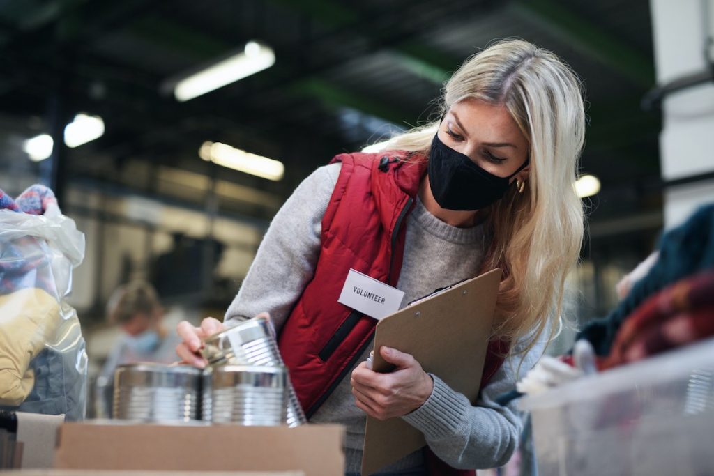 Woman checking food boxes in food bank for employee volunteer program