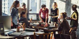 Marketing team stood around desk coming up with campaign concept