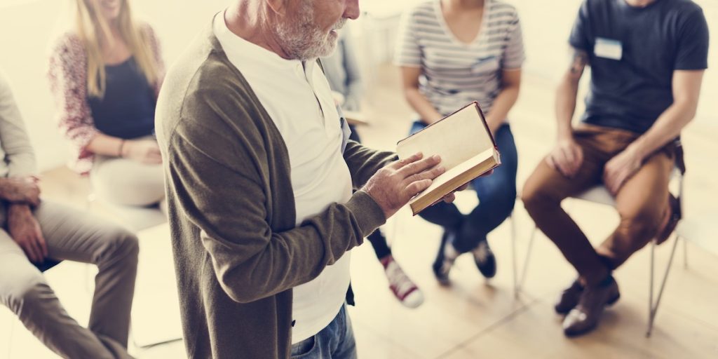 Employees sat in an employee book club meet up listening to man read