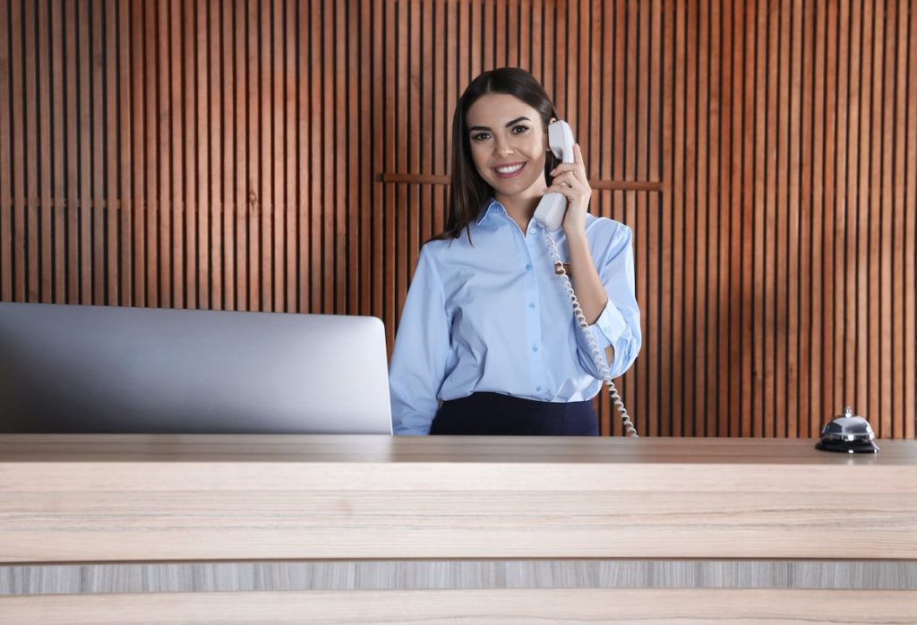 Receptionist talking on phone at desk for call centre service