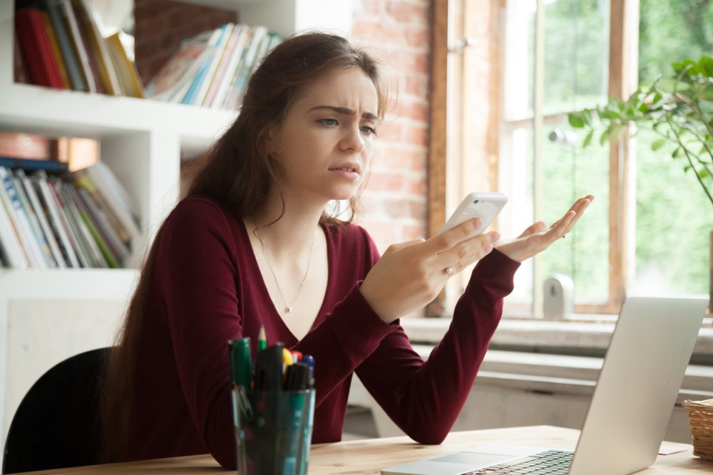 Frustrated woman looking at smartphone