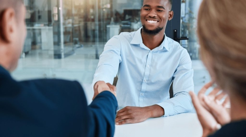 Smiling man shaking hands in meeting room