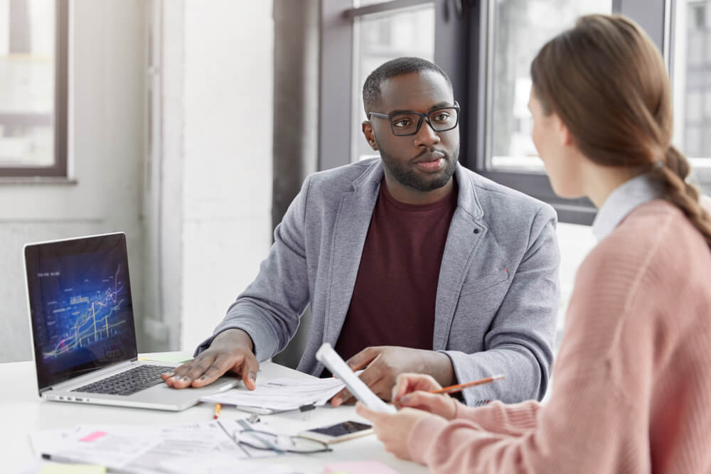 Man training receptionist in office setting