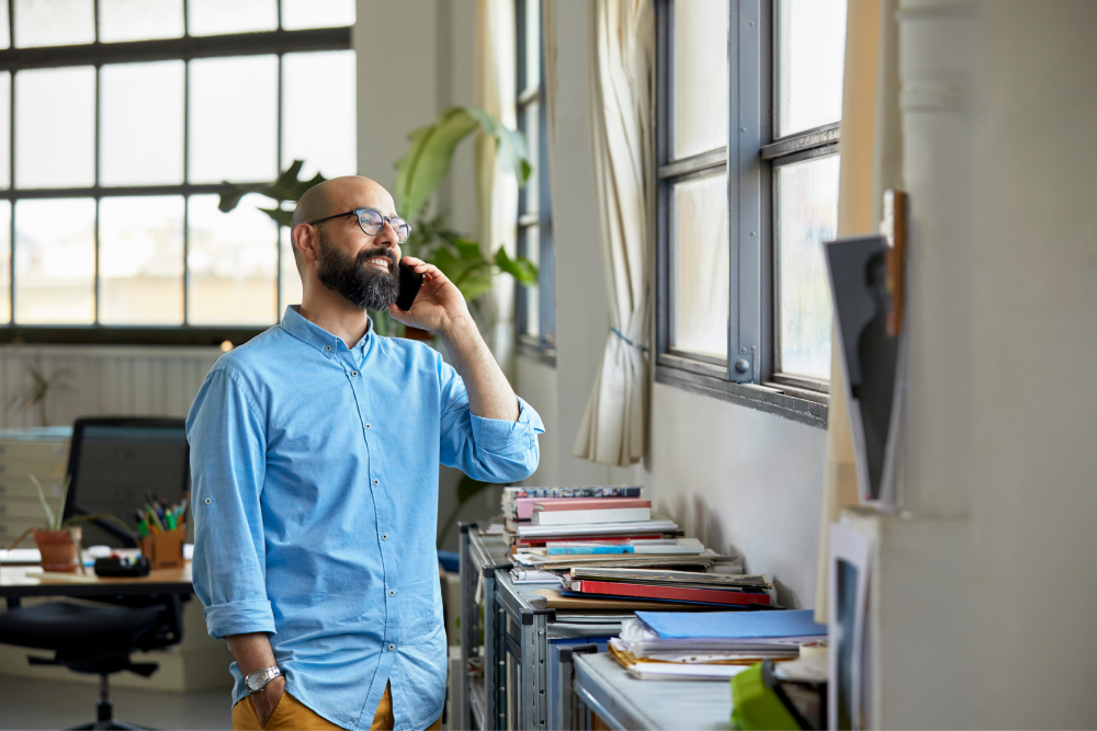 A man in blue shirt talking on the phone