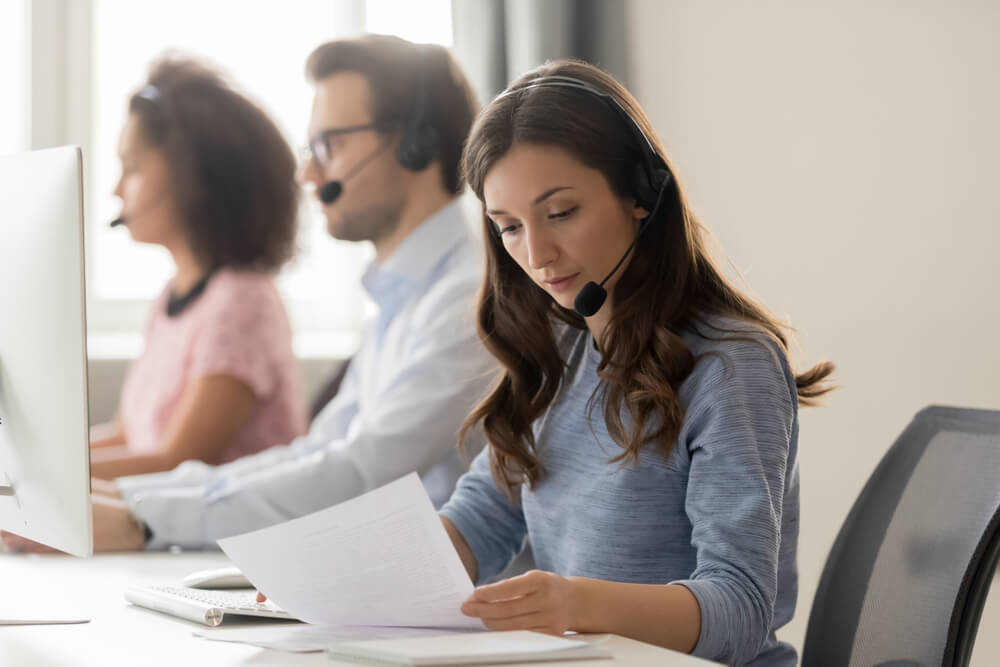 Receptionist using CARP method to respond to caller through headset in office setting