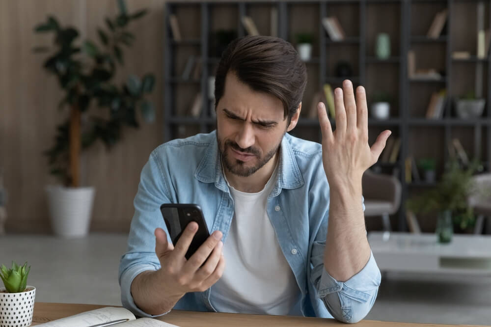 Man angrily looking at the phone