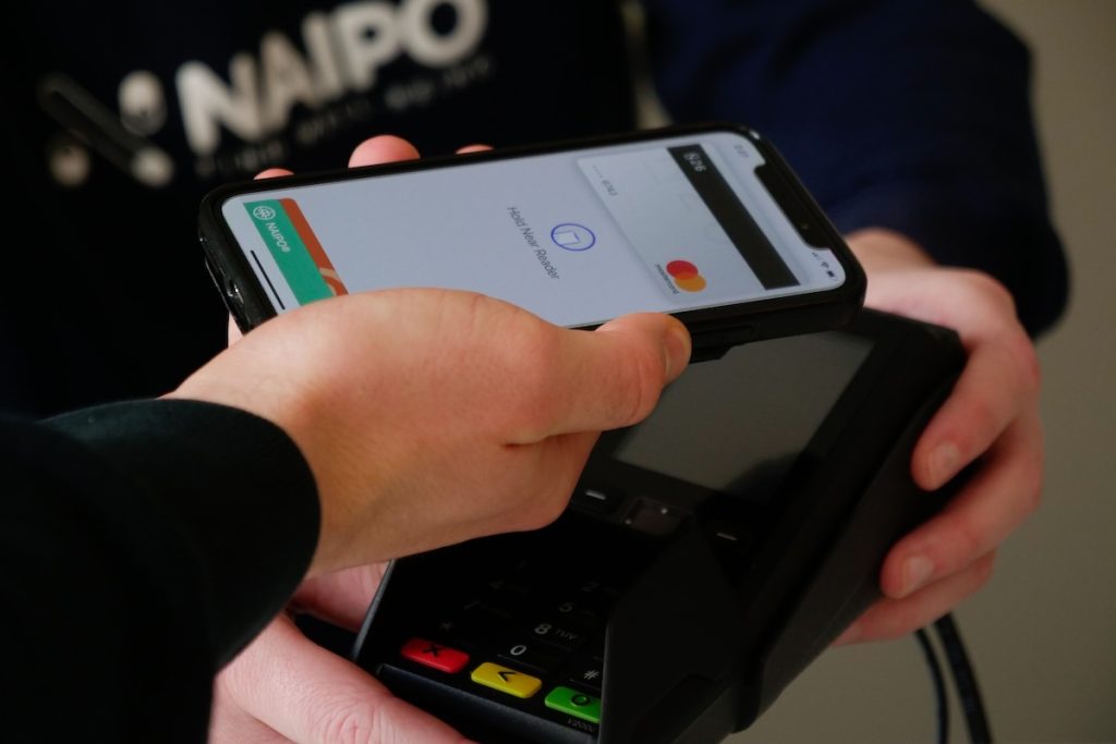 Small business strategies: person paying via smartphone contactless