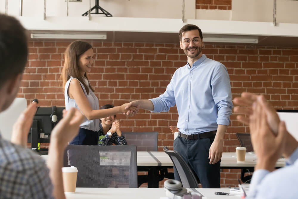 Man and woman shaking hands in office setting