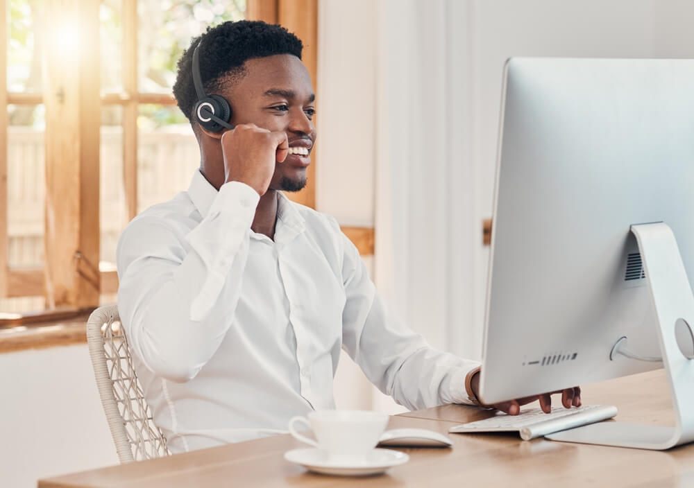 Outsourced Customer Service agent in front of computer at home

