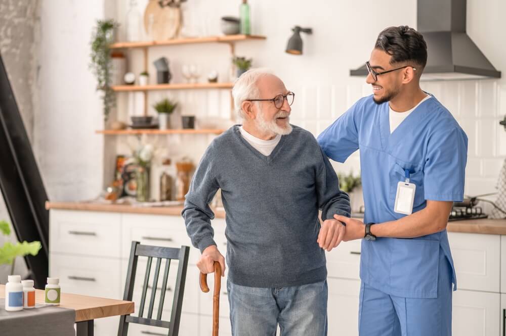 Nurse assisting elderly man with daily activities.