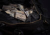 Leather bag with lots of dollar bills