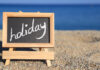 Blackboard with holiday text on the beach