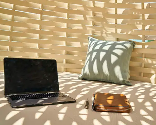 En laptop, penn og notatbok på en pute. Fras Engin Akyurt på Unsplash