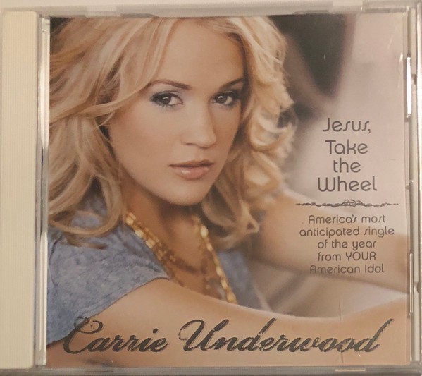 The cover of the CD single "Jesus, Take the Wheel" by Carrie Underwood. It features her facing right and looking at the camera, with wavy blonde hair, a grey shirt, and a necklace, with the additional text, "America's most anticipated single of the year from YOUR American Idol."