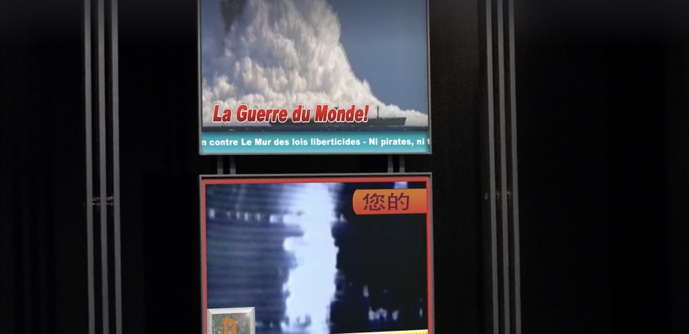 Two TV screens showing the news, one in French and one in Chinese. The French one says "La Guerre du Monde!" and shows what looks like an impact or explosion at sea with a ship in the foreground. The Chinese one shows a blurry column of fire and/or smoke at night.