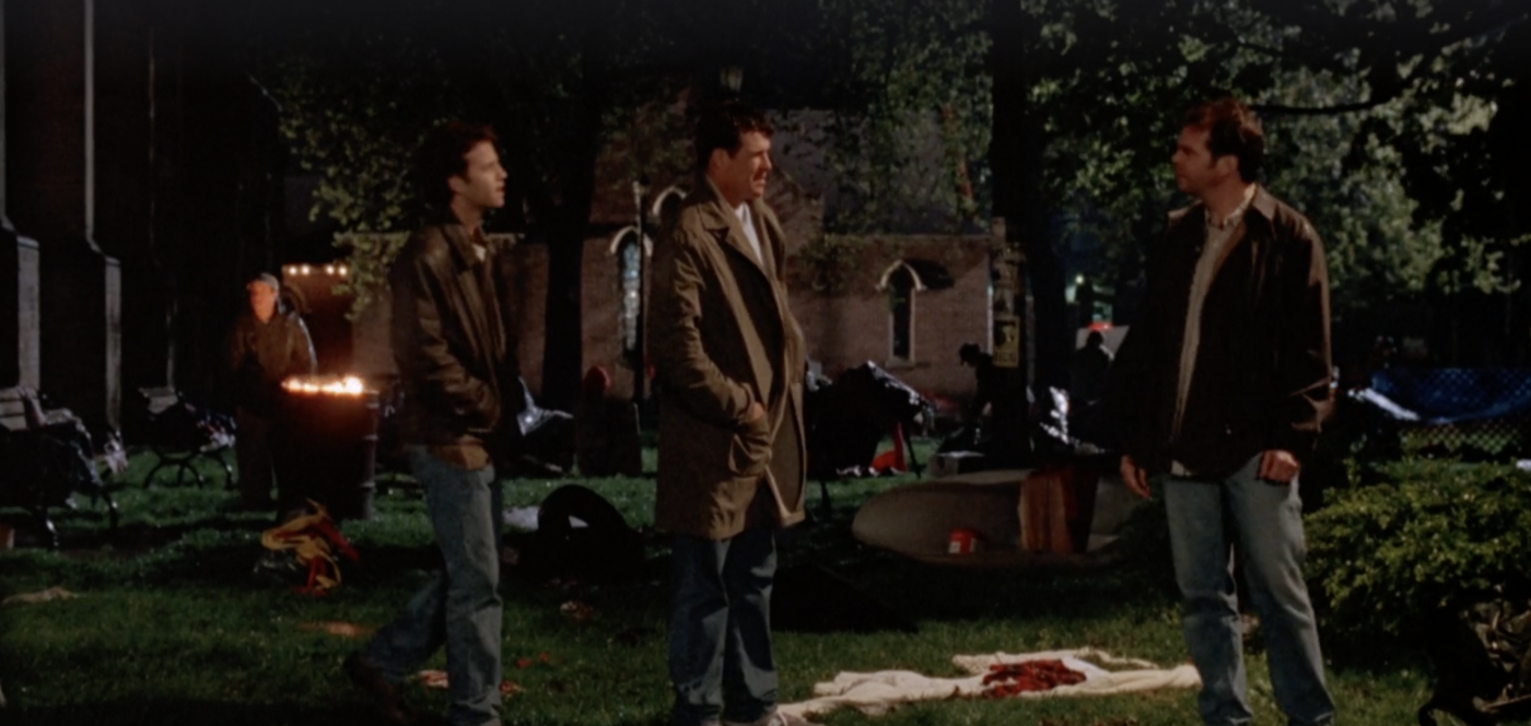 Buck and Rayford with their hands in their jacket pockets addressing Chris in a churchyard at night.