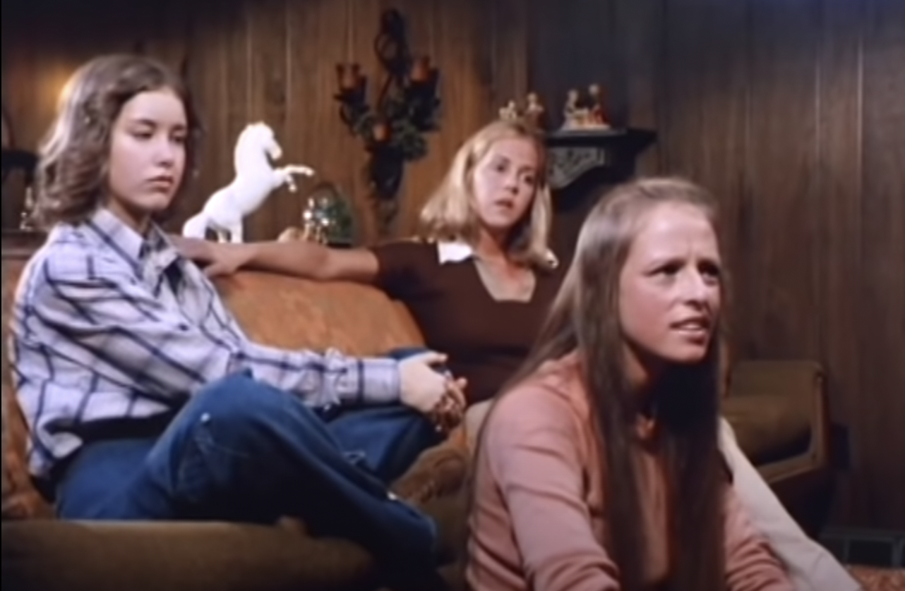 Sandy, Wenda, and Patty sitting on a couch, with a white horse statue in the background.