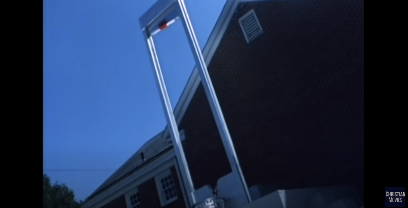 An angled picture of a guillotine with a bloodstain on the blade and where the victim's head goes at the bottom.