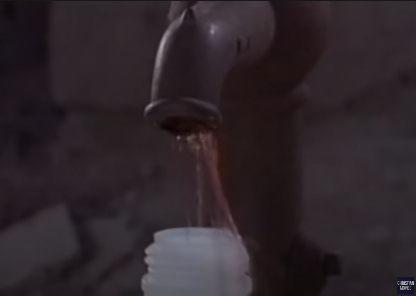 A tap dripping red liquid into a bottle.