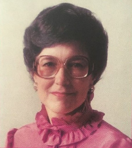 Carole C. Carlson in a pink ruffly top with big pink translucent sunglasses.