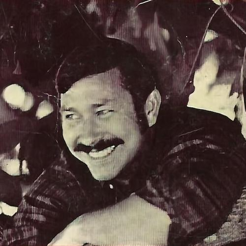 Hal Lindsey with a moustache wearing a plaid shirt leaning on a tree around age 40, some time before the release of his book in 1970.